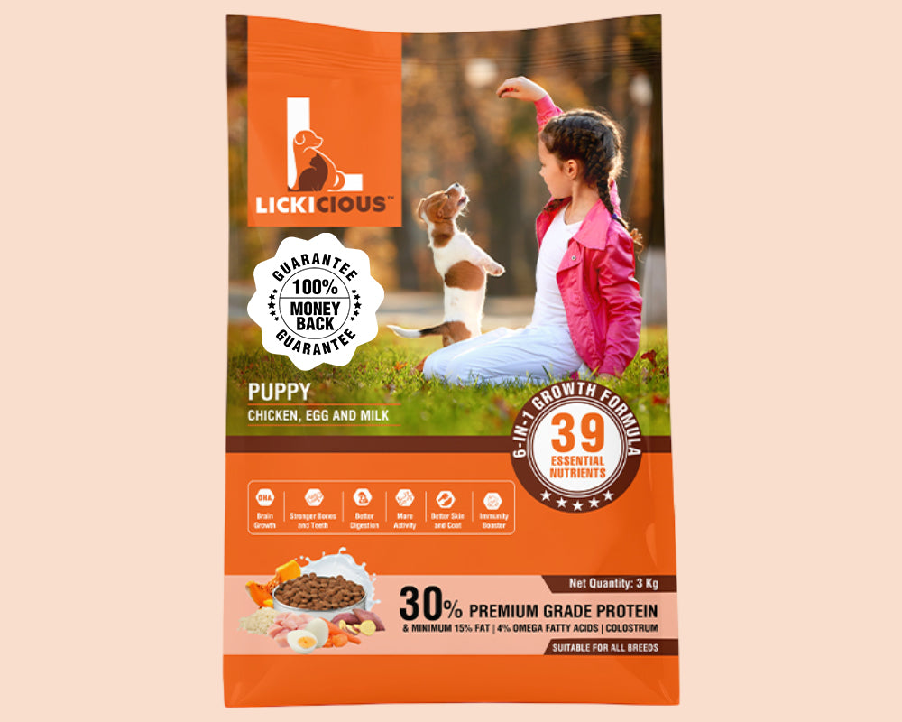 A 3 kg bag of Lickicious Puppy dog food, featuring an orange and brown packaging design with a photo of a girl feeding a dog outdoors. The bag highlights 'Puppy Chicken, Egg and Milk' flavor and '30% Premium Grade Protein'.